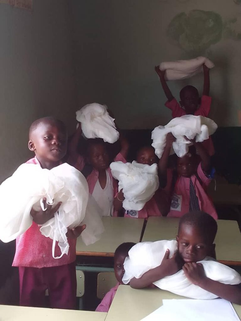 Vier gambische Kinder halten Moskitonetze